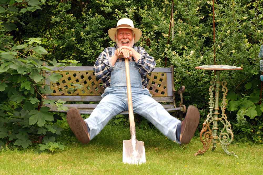 Ein älterer Herr mit Spaten im Garten