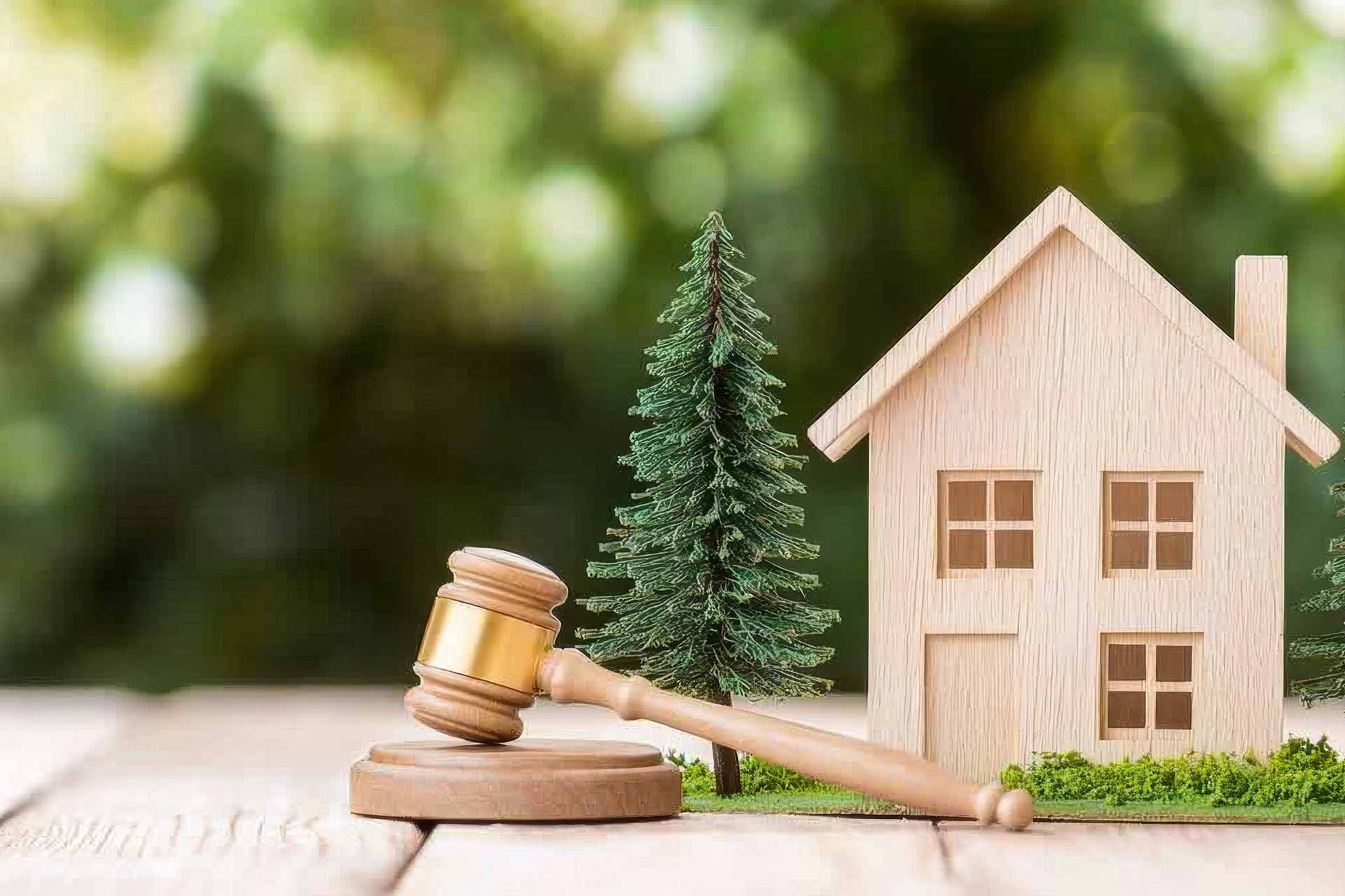 Modellhaus und Richterhammer als Symbol für Erbschaften, Alleinerben
